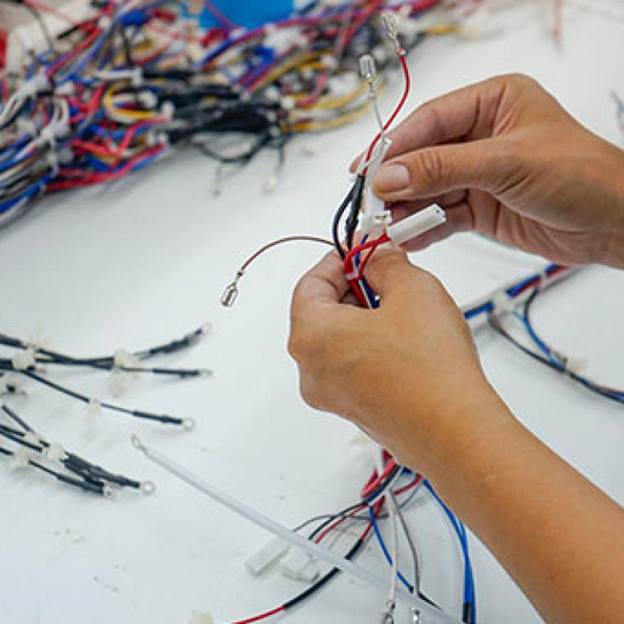 Skilled technicians assembling a wiring harness